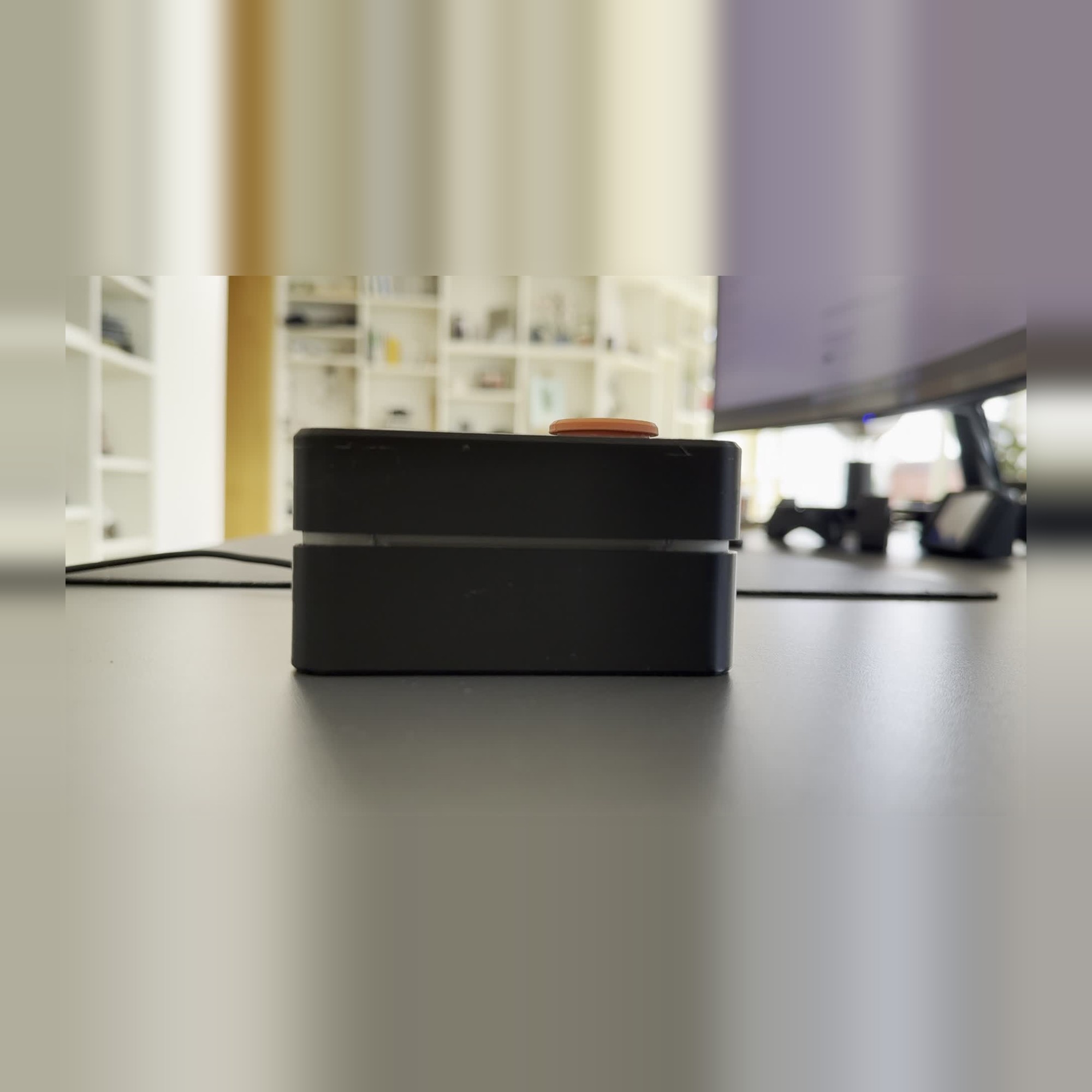 Breathe on a desk, top closed, orange button on top